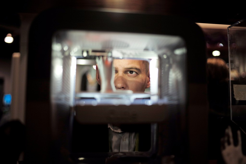 Ian Schick relojes una mano de plástico que se está imprimiendo en una impresora 3D en el stand de 3D Systems en el CES Internacional, 7 de enero de 2015, en Las Vegas.  Jae C. Hong / AP